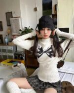 Model wearing a Korean aesthetic sweater with a bowknot print detail.