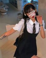 Woman wearing a korean aesthetic dress, white shirt, and black suspender dress.