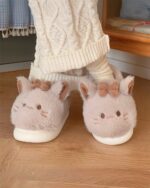 Pink kawaii cat slippers with bow accents, featuring soft plush material.