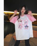 Woman wearing a kitty pink t-shirt with star graphics. Kawaii clothes style.