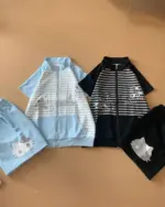 Two sets of japanese striped loungewear: a blue zip-up jacket and shorts, and a black zip-up jacket and shorts, both with cat graphics.