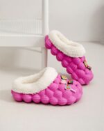 Pink casual fluffy foam slippers with a plush white lining and decorative charms.