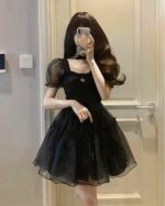 Black aesthetic vintage dress with puff sleeves and a gathered skirt.