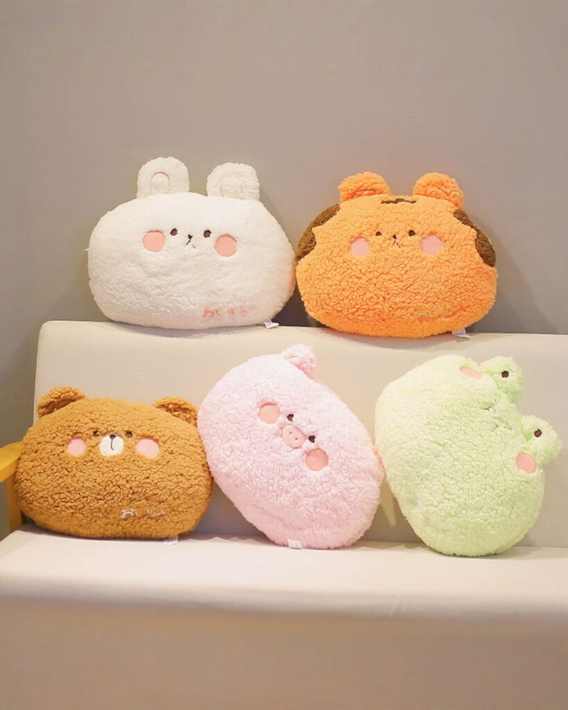 Selection of kawaii animal plushie cushions featuring bunny, bear, pig, and chick designs.