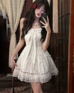 White lolita white laced dress with lace details and ruffles, featuring a sweetheart neckline and straps.