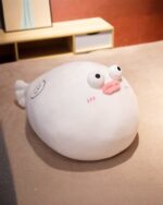 White pufferfish plush toy displayed on a wooden surface.