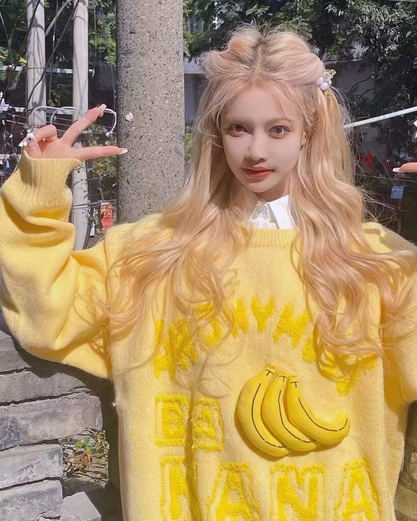 Model wearing a yellow vintage banana sweater featuring banana illustrations.