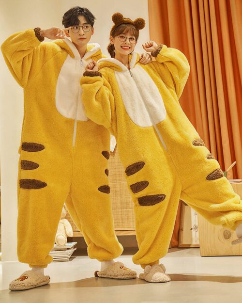 Couple wearing yellow dino-shark jumpsuit with brown details and slippers.