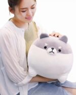 A white and gray super fat shiba plushie, a chonky dog stuffed animal, being held by a person.