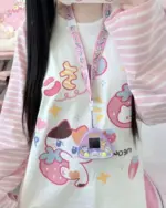 Close-up of a kawaii striped shirt with character print and lanyard.
