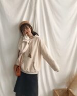 Cream colored ethno-chic hoodie with embroidered details, featuring a relaxed fit.