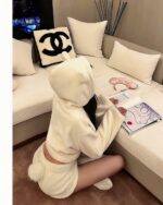 Plush hooded pajamas worn by a person on a couch, reading a magazine.