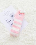Close-up of kawaii fluffy socks featuring animal ears and a pink pompom.
