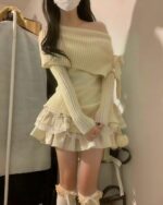 Cream-colored one-shoulder knitwear sweater with ruffled skirt and sleeves.