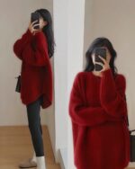 Woman wearing a red korean style sweater, holding a smartphone.