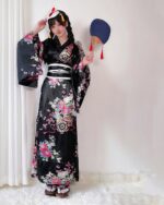 Woman wearing a traditional Japanese aesthetic yukata with floral patterns, holding a fan.