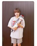 A long cat plushie, Whiskers the Stripped Emperor Cat, is held by a woman.