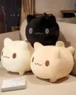 Two round neko plushies, one black and one beige, displayed on a table.