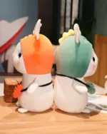 Two kawaii bunny plushies, one orange and one green, with hats and carrots. Aesthetic rabbit toy.