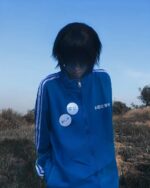 Blue japanese sporty jacket worn by a person outdoors.