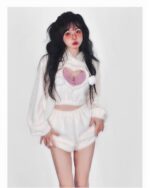 Model wearing a white kawaii fluffy pajamas set, featuring a hooded top and shorts with bear details.