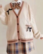 Cream-colored kawaii bow sweater with cable knit details and ribbon accents.