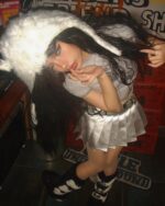 Person wearing a silver pleated skirt at a club, coquette aesthetic.