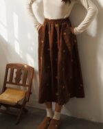 Brown corduroy retro aesthetic skirt embroidered with small yellow flowers and stars.