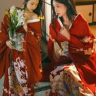 Two women wearing a vibrant red aesthetic kimono with floral patterns. They hold lilies and appear to be indoors.