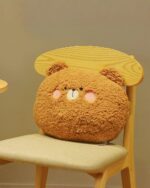 Kawaii animal plushie cushion on a wooden chair, soft and round design.