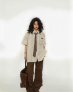 Vintage striped short sleeve shirt in preppy aesthetic style, featuring a light beige color and vertical stripes.