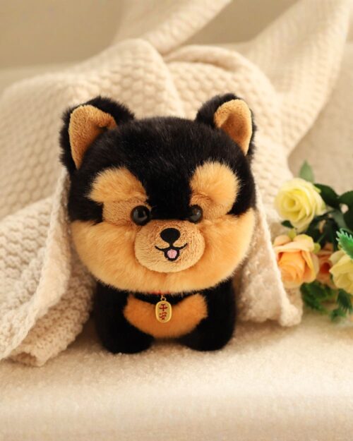 Close-up of a brown and black puppy collectible plush with a tag and stitched face.
