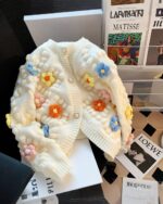 Cream-colored handmade aesthetic cardigan with floral embellishments.