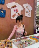 Retro pink cutecore top worn by a person at a market stall with accessories.