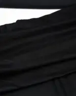Close-up of black fabric, gothic aesthetic dress material.
