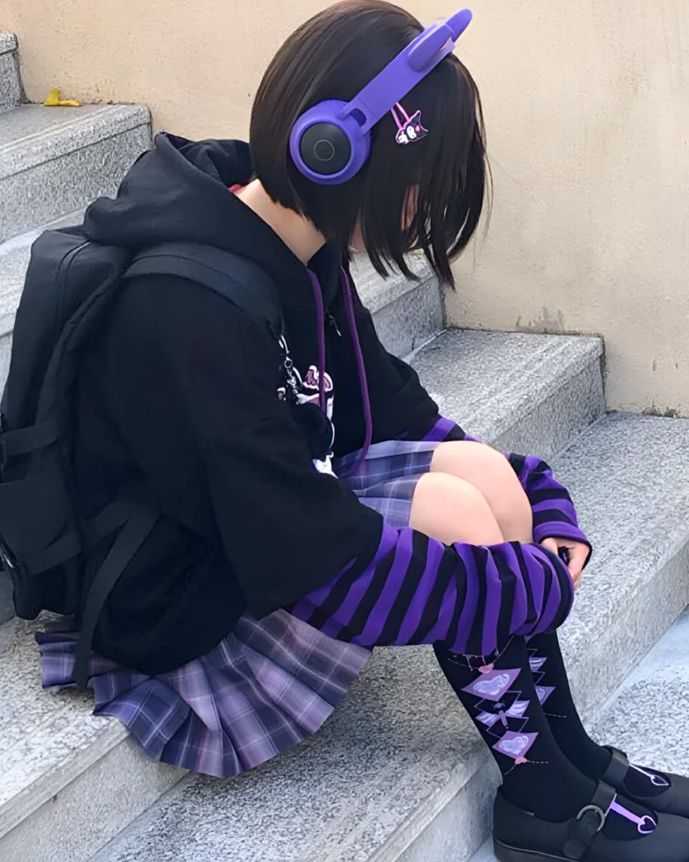 Woman wearing a Kawaii Cartoon Hoodie, headphones, and striped socks while sitting on steps.