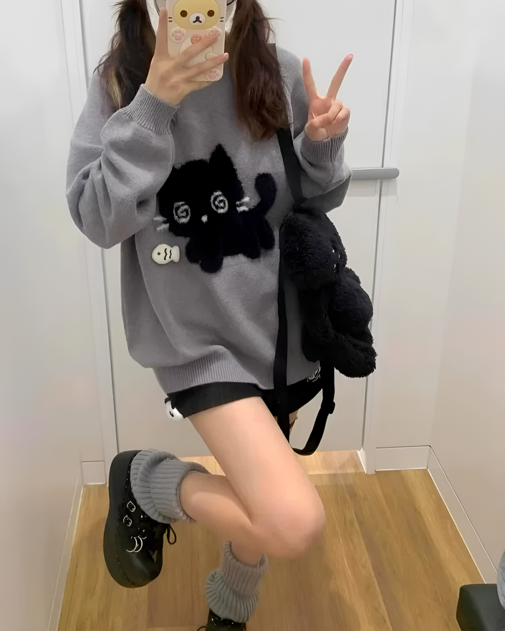 Model wearing a vintage-style Black Neko Sweater with a plush cat embellishment.