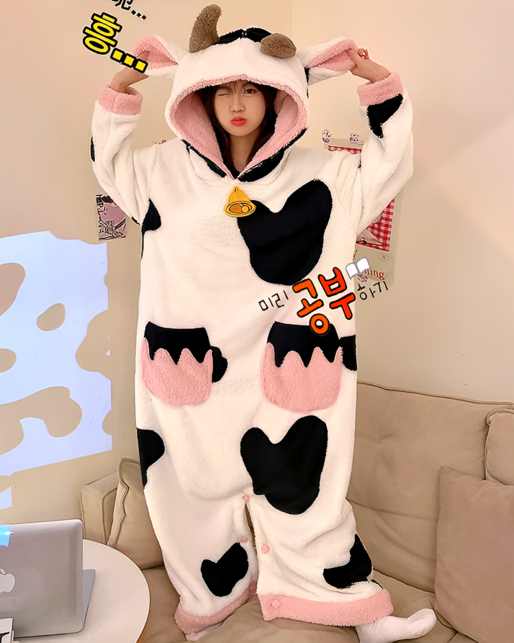 A pink and black Cow Onesie - Kawaii Pajamas with hood and ears, featuring a cozy fleece design.