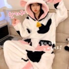 Pink and black Cow Onesie - Kawaii Pajamas featuring a hood and ears, shown in a bedroom setting.
