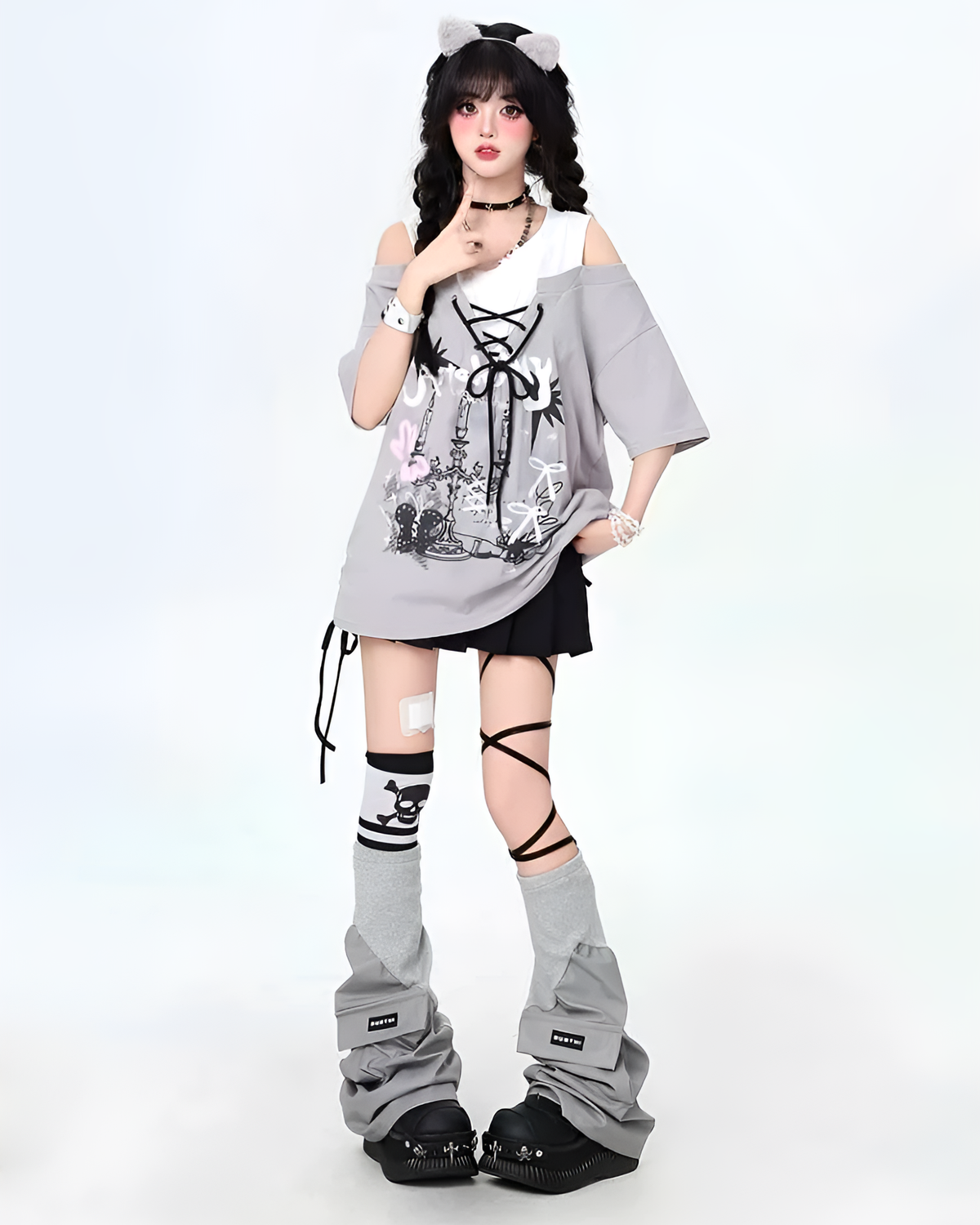 Model wearing a Grunge Aesthetic Top with a graphic print, layered with a loose t-shirt and paired with leggings and boots.