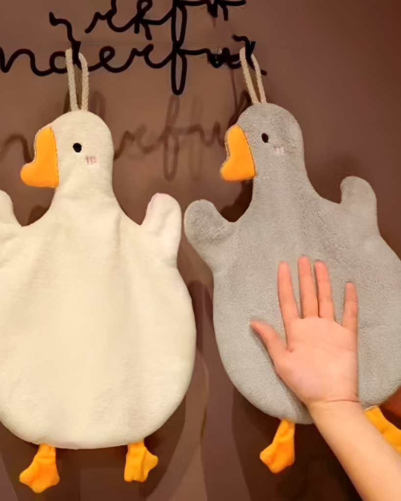 Two Goose Hand Towels shown, featuring plush gray bodies and orange beaks.