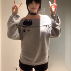 Gray Grak Cat Off-Shoulder T-Shirt with cat paw prints, worn by a person.