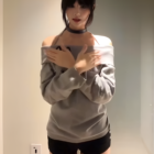 Model wearing a gray Grak Cat Off-Shoulder T-Shirt, black shorts, and thigh-high socks.