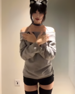 Model wearing a gray Grak Cat Off-Shoulder T-Shirt, black shorts, and thigh-high socks.