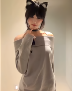 Gray Grak Cat Off-Shoulder T-Shirt with paw print detail, worn by a person.