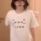 White Kaomoji Cat T-Shirt worn by a person. Kawaii clothing design.