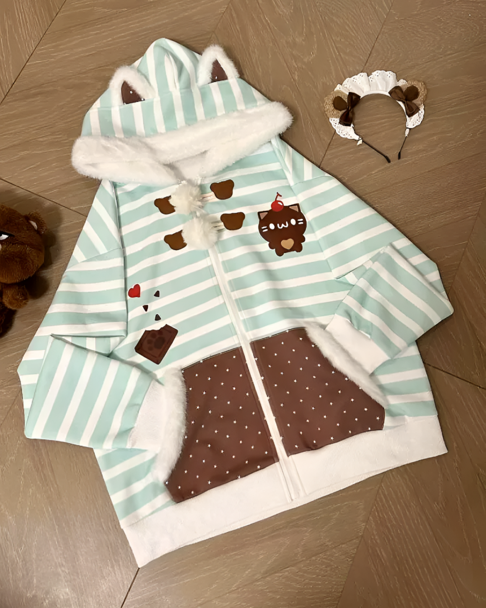Mint Furry Hoodie with bear ears and a striped design on a wooden floor.