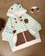 Mint Furry Hoodie with bear ears and a striped design on a wooden floor.