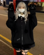 Person wearing a Neko Paw Hoodie with cat paw sleeves on a nighttime street.