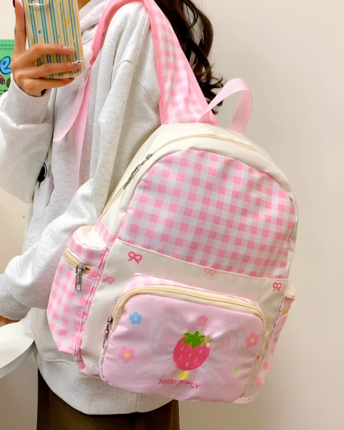 Plaid Strawberry Backpack featuring a strawberry design and ribbons. NHSUPPLY logo.